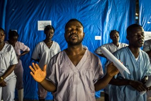 Health workers pray before the start of their shift at the Bong County Ebola Treatment Unit in Suakoko, Liberia, on Oct. 6, 2014. Daniel Berehulak was awarded the Pulitzer Prize for feature photography on April 20, 2015, for his coverage of the Ebola outbreak in West Africa for The New York Times.Credit: © Daniel Berehulak, The New York Times/Redux Pictures