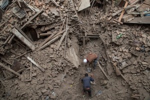 Two men help clear debris after buildings collapsed on April 26, 2015 in Bhaktapur, Nepal. A major 7.8 earthquake hit Kathmandu mid-day on Saturday, and was followed by multiple aftershocks that triggered avalanches on Mt. Everest that buried mountain climbers in their base camps. Many houses, buildings and temples in the capital were destroyed during the earthquake, leaving thousands dead or trapped under the debris as emergency rescue workers attempt to clear debris and find survivors.Credit: © Omar Havana, Getty Images