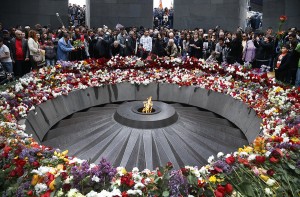 People lay flowers at a memorial to the Armenians who were killed by the Ottoman Empire, as they mark the centenary of the mass killings, in Yerevan, Armenia, Friday, April 24, 2015. Credit: AP Photo