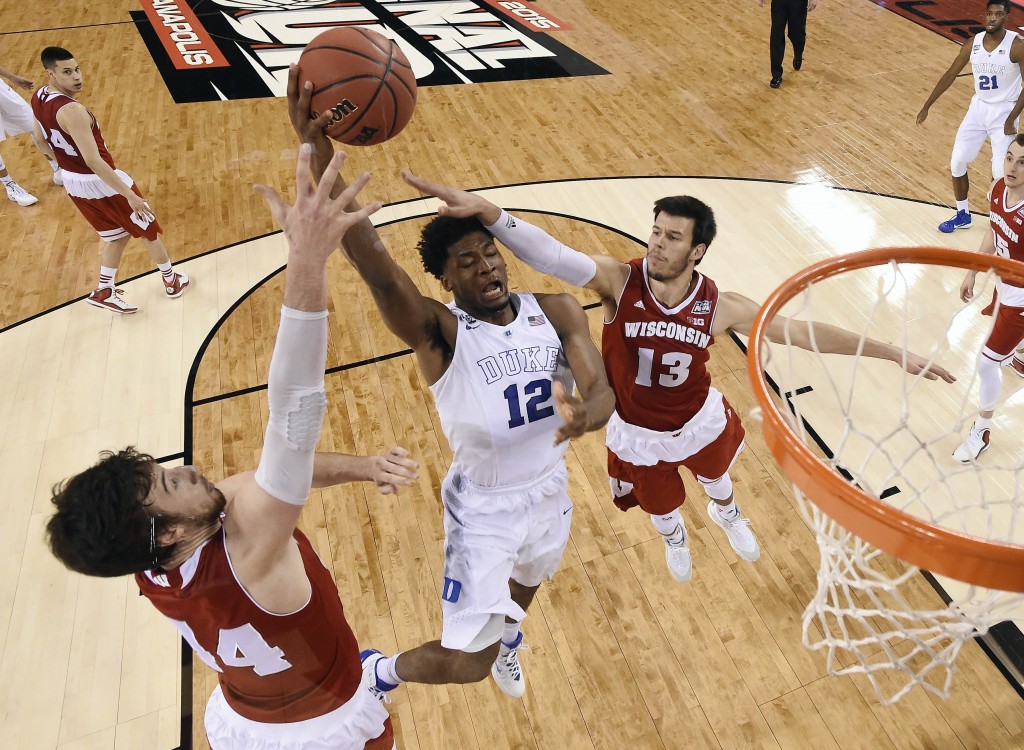 Duke's Justise Winslow (12) goes up for a shot between Wisconsin's Frank Kaminsky (44) and Duje Dukan (13) during the NCAA championship game. Credit: AP Photo