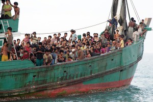 Migrants sit on their boat as they wait to be rescued by Acehnese fishermen on the sea off East Aceh, Indonesia, Wednesday, May 20, 2015. Hundreds of migrants stranded at sea for months were rescued and taken to Indonesia, officials said Wednesday, the latest in a stream of Rohingya and Bangladeshi migrants to reach shore in a growing crisis confronting Southeast Asia. Credit: AP Photo