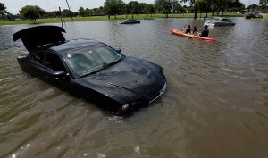 People kayak down a flooded street in Houston, Texas on May 26, 2015. (AP Photo/David J. Phillip)