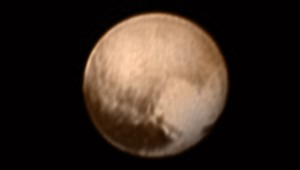 An image snapped on July 7 by the New Horizons spacecraft while just under 5 million miles (8 million kilometers) from Pluto is combined with color data in this most detailed view yet of the Solar System's most famous world about to be explored. The region imaged includes the tip of an elongated dark area along Pluto's equator already dubbed "the whale". A bright heart-shaped region on the right is about 1,200 miles (2,000) kilometers across, possibly covered with a frost of frozen methane, nitrogen, and/or carbon monoxide. The view is centered near the area that will be seen during New Horizons much anticipated July 14 closest approach to a distance of about 7,750 miles (12,500 kilometers). Credit: NASA/Johns Hopkins Univ./APL/Southwest Research Inst.