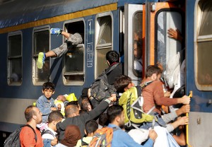Refugees storm a train at the Keleti train station in Budapest, Hungary, On September 3, as Hungarian police withdrew from the station's gates after two days of blocking them. (Credit: © Laszlo Balogh, Reuters/Landov)