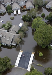 People stand on the safety of a bridge as homes sit in floodwater in a subdivision west of the Ashley river in Charleston, S.C., Monday, Oct. 5, 2015. The Charleston and surrounding areas are still struggling with floodwaters due to a slow moving storm system Credit: © Mic Smith, AP Photo