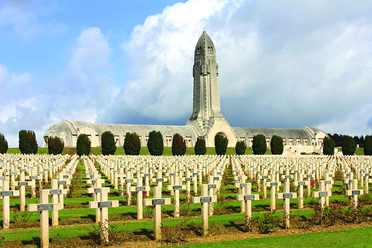 Graves of French soldiers surround the Douaumont Ossuary near Verdun, France. The ossuary holds the remains of about 130,000 unidentified soldiers killed on nearby battlefields. Credit: © Julia Gavin, Alamy Images