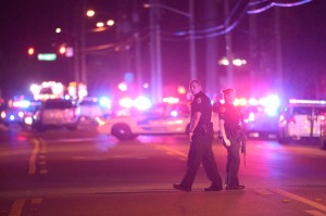 Police officers stand guard down the street from the scene of a shooting involving multiple fatalities at a nightclub in Orlando, Fla., Sunday, June 12, 2016. Credit: © Phelan M. Ebenhack, AP Photo
