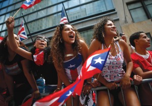 Spectators cheer during the Puerto Rican Day Parade in New York City. The event is held every June in recognition of the achievements and influence of Puerto Ricans and other Latinos in the city. Spectators cheer during Puerto Rican Day Parade in New York June 14, 2009. Thousands of people lined both sides of Fifth Avenue for the annual parade, which recognizes the achievements and influence of Puerto Ricans and Latinos in the city. Credit: © Eric Thayer, Reuters/Landov
