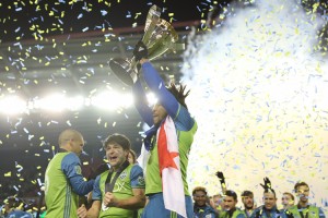 Defender Román Torres hoists the trophy. Credit: © Dan Poss, Seattle Sounders FC Communications