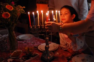 A family is lighting a candle for the Jewish holiday of Hanukkah. Credit: © Shutterstock