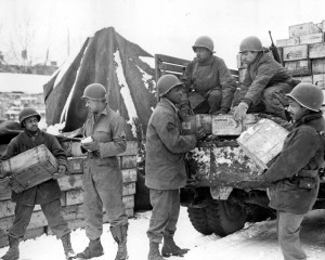 Soldiers load trucks with rations bound for frontline troops. From left to right are Pvt. Harold Hendricks, Staff Sgt. Carl Haines, Sgt. Theodore Cutright, Pvt. Lawrence Buckhalter, Pfc. Horace Deahl and Pvt. David N. Hatcher. The troops were assigned to the 4185th Quartermaster Service Company, Liege, Belgium. Credit: Army Transportation Museum