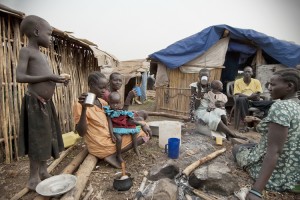 Unidentified people have breakfast in front of their huts in displaced persons camp, Juba, South Sudan, February 28, 2012. They stay in harsh conditions for long time. Credit: © Vlad Karavaev, Shutterstock