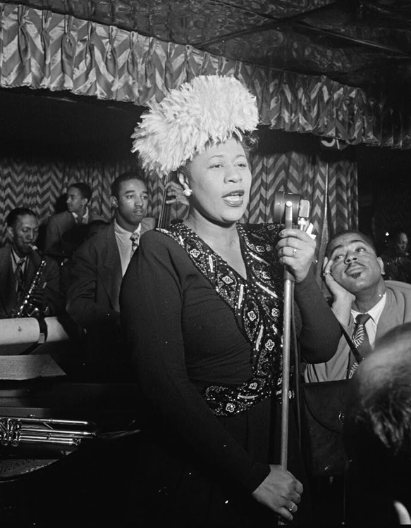 Ella Fitzgerald was among the finest and most popular singers in jazz history. She became known for her ability to improvise through scat singing (rhythmic, wordless syllables sung instead of lyrics). This photograph shows Fitzgerald performing with bassist Ray Brown while trumpet player Dizzy Gillespie looks on. Credit: Library of Congress