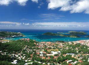 The city of Charlotte Amalie, on St. Thomas, is the capital of the United States Virgin Islands. Ocean liners, like the one shown in the distance, transport many tourists to the islands each year. Credit: © Steve Simonsen