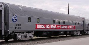 The Ringling Bros. and Barnum & Baily Circus traveled by train—the last circus to do so—right up to the show's final performance in May 2017. Built as former Pennsylvania Railroad (PRR) stainless steel, 21-roomette sleeper No. 8267 ("Lewistown Inn") in 1949 by the Budd Company, using Pullman Plan #9513. Rebuilt in 1963 as a 64-seat coach with 12-seat smoking lounge, and renumbered PRR 1505. Became Penn Central (PC) 1505 in 1968. Sold to New Jersey Transit in 1976 and renumbered NJTR 5439. Traded to a private car owner in 1992, who in turn sold it to RBBB Circus. Rebuilt by RBBB at their Palmetto FL railcar recycling center, and entered service on the "RED UNIT" Circus as "RBX 38" -- housing members of the Circus BAND. Renumbered ["House Car Number"] 37 during 1995, with railroad reporting marks changed to RBBX 41307 during that year. Car would later (during the early 2000s) be placed into service on the Circus "BLUE UNIT," with "House Number" 186, where it is today (as of 2007). Credit: © Harvey Henkelman