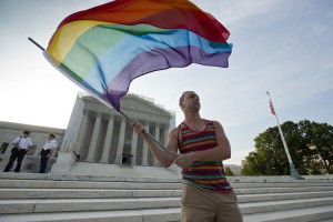 An activist for lesbian, gay, bisexual, and transgender (LGBT) rights waves a rainbow flag in front of the Supreme Court Building in Washington, D.C. The rainbow flag is a symbol of LGBT pride. Credit: © AP Photo