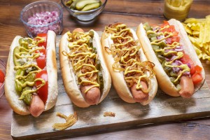 Group of Delicious Gourmet Grilled Hot Dogs With Mustard, Pickles, Onion and Chips. Credit: © Olga Nayashkova, Shutterstock