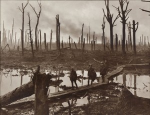 Battle of Passchendaele (Third Battle of Ypres) -- Soldiers of an Australian 4th Division field artillery brigade on a duckboard track passing through Chateau Wood, near Hooge in the Ypres salient, 29 October 1917. The leading soldier is Gunner James Fulton and the second soldier is Lieutenant Anthony Devine. The men belong to a battery of the 10th Field Artillery Brigade. Credit: Frank Hurley, Australian War Memorial