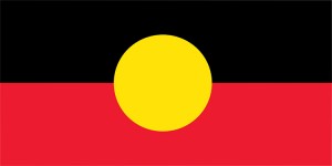 The Aboriginal flag features a black rectangle (representing Australia's Aboriginal peoples) atop a red rectangle (representing the red soil of their traditional land). In the center of the flag is a yellow circle representing the sun, uniting the people with their land. The flag was designed in 1971 by Aboriginal artist Harold Joseph Thomas. Credit: © Harold Thomas. Used with permission.