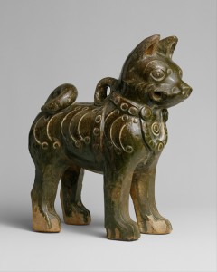 This glazed pottery figure depicts a dog with a menacing look, marked by its raised ears, staring eyes, and tightly clenched jaws. Its studded collar, a fashionable accessory of the time, suggests that the animal was a pet with a wealthy master. During the Han dynasty, it was common practice to bury pottery models of dogs in graves, in the belief that they would keep the deceased humans company in the afterlife.  Credit: Figure of a Dog (Eastern Han dynasty (25–220), earthenware with dark green glaze; Metropolitan Museum of Art