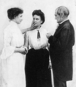 Helen Keller "listened" to others speak by putting her middle finger on the speaker's nose, forefinger on the lips, and thumb on the larynx. With Anne Sullivan, she demonstrated the method for the American actor Joseph Jefferson. Credit: Bettmann Archive
