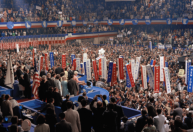 At a national political convention, delegates nominate their party's candidates for president and vice president. This crowd of supporters celebrates the nomination of Hubert Humphrey and his running mate, Senator Edmund S. Muskie, at the 1968 Democratic Party convention in Chicago. Humphrey and Muskie stand on the podium with their wives. Credit: AP Photo 