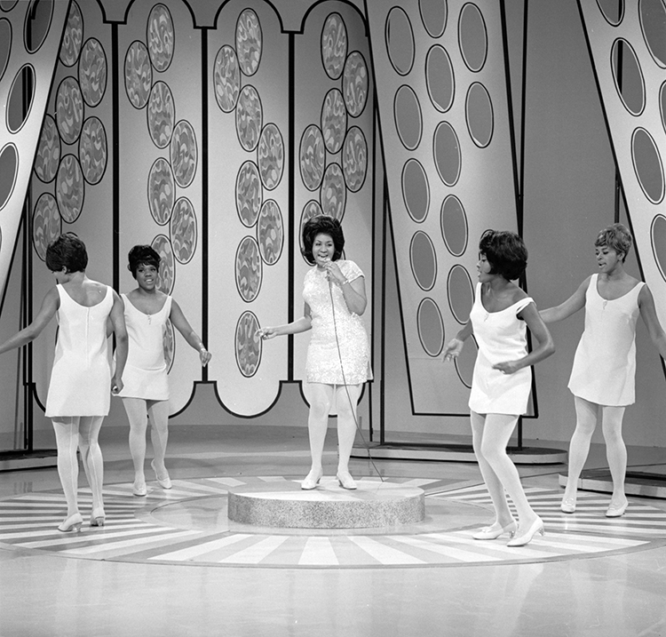 Aretha Franklin, center, is an American rhythm and blues singer. She ranks among the best-selling female artists in the history of recorded music. Franklin is popularly known as the "Queen of Soul." This photograph shows her performing on an American television program in 1968. Credit: © CBS/Landov 