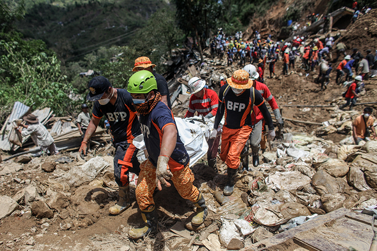 Members of the Filipino Bureau of Fire Protection carry a victim of a landslide in Luzon’s Benguet province on Sept. 18, 2018. The landslide, triggered by Typhoon Mangkhut, killed 69 people. Filipino rescuers carry a body of a person inside a body bag at the site where people were believed to have been buried by a landslide on September 18, 2018 in in Itogon, Benguet province, Philippines. At least 36 people are feared to be buried by a landslide in the mining town of Itogon, in Benghuet province, after Super Typhoon Mangkhut triggered a massive landslide in northern Philippines which destroyed hundreds of homes and killed over 60 people. The storm slammed into the main Philippine island of Luzon over the weekend and continued its path through Hong Kong and Southern China, killing four people in the province of Guangdong as 2.5 million people were evacuated in Guangdong and on Hainan island. Credit: © Basilio Sepe, Getty Images