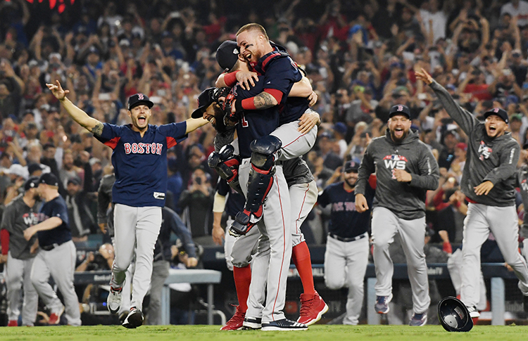 Red Sox players jubilantly rush the mound as catcher Christian Vázquez leaps into the arms of pitcher Chris Sale, who recorded the final out of Boston’s World Series-clinching 5-1 win over the Los Angeles Dodgers on Oct. 28, 2018, at Dodger Stadium. Christian Vazquez #7 jumps into the arms of Chris Sale #41 of the Boston Red Sox to celebrate their 5-1 win over the Los Angeles Dodgers in Game Five to win the 2018 World Series at Dodger Stadium on October 28, 2018 in Los Angeles, California. Credit: © Harry How, Getty Images