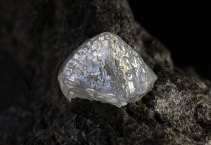 This photograph shows a naturally occurring diamond embedded in a sample of the rock kimberlite. Diamonds may be mined from pipe-shaped deposits of kimberlite, which fill the throats of extinct volcanoes. Natural diamonds are dull and must be cut by skilled jewelers to bring out the gem's distinctive sparkle. Credit: © Matteo Chinellato, ChinellatoPhoto/Exactostock/SuperStock 