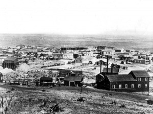 Tombstone, Arizona in 1881 photographed by C. S. Fly. An ore wagon at the center of the image is pulled by 15 or 16 mules leaving town for one of the mines or on the way to a mill. The town had a population of about 4,000 that year with 600 dwellings and two church buildings. There were 650 men working in the nearby mines. The Tough Nut hoisting works are in the right foreground. The firehouse is behind the ore wagons, with the Russ House hotel just to the left of it. The dark, tall building above the Russ House is the Grand Hotel, and the top of Schieffelin Hall (1881) is visible to the right. Credit: Public Domain