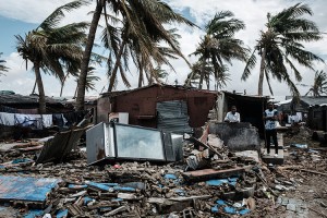 An owner (2nd R) stays at his destroyed bar after the cyclon Idai hit near the beach in Beira, Mozambique, on March 23, 2019. - The death toll in Mozambique on March 23, 2019 climbed to 417 after a cyclone pummelled swathes of the southern African country, flooding thousands of square kilometres, as the UN stepped up calls for more help for survivors. Cyclone Idai smashed into the coast of central Mozambique last week, unleashing hurricane-force winds and rains that flooded the hinterland and drenched eastern Zimbabwe leaving a trail of destruction. Credit: © Yasuyoshi Chiba, AFP/Getty Images