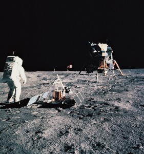 The first people on the moon were U.S. astronauts Neil A. Armstrong, who took this picture, and Buzz Aldrin, who is pictured next to a seismograph. The two made their historic moonwalk on July 21, 1969. A television camera and a United States flag are in the background. Their lunar module, Eagle, stands at the right. Credit: NASA 