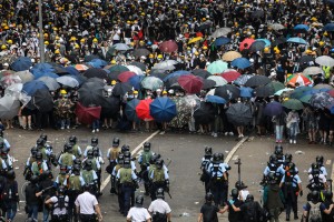 Protesters face off with police during a rally against a controversial extradition law proposal outside the government headquarters in Hong Kong on June 12, 2019. - Violent clashes broke out in Hong Kong on June 12 as police tried to stop protesters storming the city's parliament, while tens of thousands of people blocked key arteries in a show of strength against government plans to allow extraditions to China.  Credit: © Dale De La Rey, Getty Images