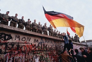 The Berlin Wall, which had divided Communist East Berlin and non-Communist West Berlin since 1961, was knocked down in 1989. The removal of the wall symbolized the collapse of Communism in Eastern Europe. This photograph shows cheering crowds and East German border guards on the day the first section was taken down. Credit:  © Tom Stoddart, Getty Images 