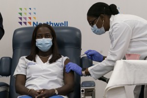 Sandra Lindsay, left, an African American nurse, is injected with the COVID-19 vaccine developed by Pfizer on Dec. 14, 2020, in the Queens borough (section) of New York City. The rollout of the vaccine, the first to be given emergency authorization by the Food and Drug Administration, begins the biggest vaccination effort in U.S. history.  Credit: © Mark Lennihan, Getty Images