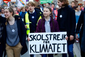 The Swedish environmental activist Greta Thunberg (holding sign) marches in a 2019 protest organized by students. As a teenager, Thunberg became known for her boldness in confronting adult politicians for their inaction on climate change due to global warming.  Credit: © Alexandros Michailidis, Shutterstock