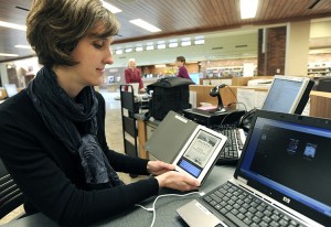 E-books are available for purchase on the websites of publishers and online bookstores. Some libraries offer e-books over the Internet at no cost. In this picture, a librarian demonstrates how to download a library book onto an e-reader. Credit: AP Photo