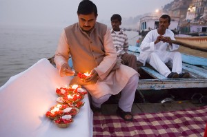 During Diwali, a major Hindu festival, people decorate their homes and temples with small earthenware oil lamps. The name Diwali comes from a Sanskrit word meaning row of lights. This picture shows a man in India lighting Diwali lamps that are decorated with flowers. Credit: © Bob Krist, Corbis