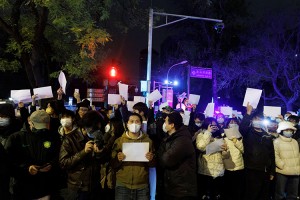 People hold white sheets of paper in protest over coronavirus disease (COVID-19) restrictions after a vigil for the victims of a fire in Urumqi, as outbreaks of COVID-19 continue, in Beijing, China, November 28, 2022.  Credit: © Thomas Peter, Reuters/Alamy Images